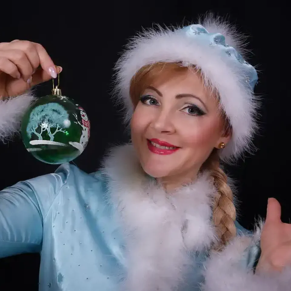 Ina Popov deschid cadouri sub bradul de Crăciun, decorat cu globuri strălucitoare și luminițe